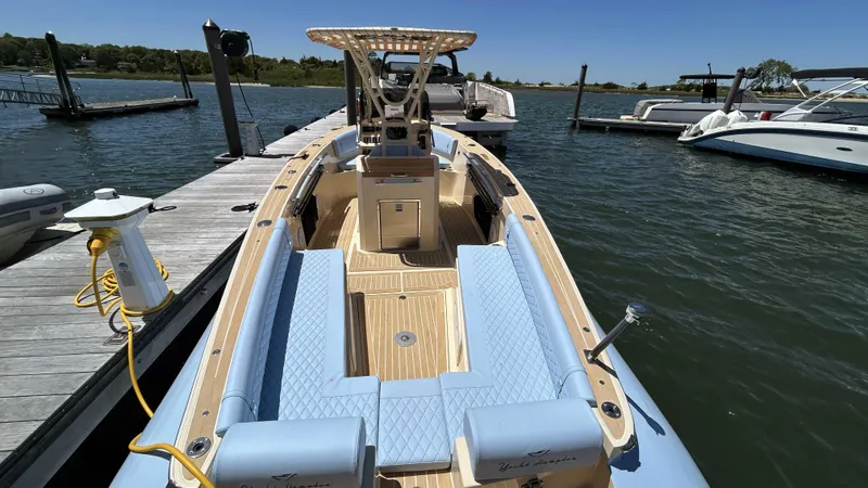 Slide: The Image of 2025 Lilybaeum Levenzo boat docked, featuring light blue seating and wooden deck. - 9