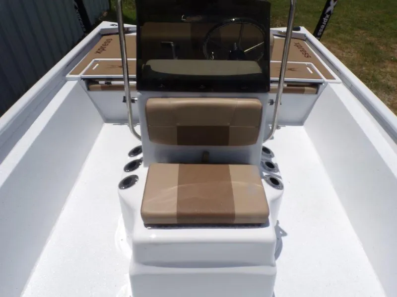 Slide: The Image of 2026 Xpress XP20CC boat interior with beige seating and console, featuring multiple cup holders. - 8