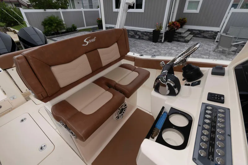 Slide: The Image of 2023 Scout 277 LXF boat interior with brown leather seating and modern control panel. - 11