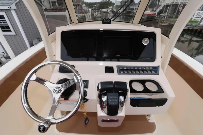 Slide: The Image of 2023 Scout 277 LXF boat helm with steering wheel and control panel. - 12