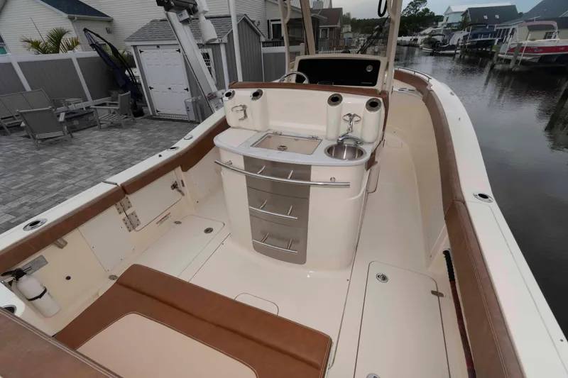 Slide: The Image of 2023 Scout 277 LXF boat interior with seating and kitchenette by a canal. - 15