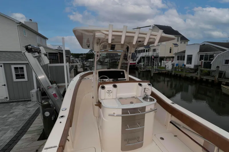 Slide: The Image of 2023 Scout 277 LXF boat docked in a residential canal setting. - 17