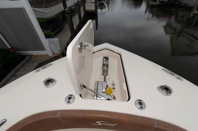Slide: The Image of 2023 Scout 277 LXF boat anchor compartment, open hatch, dockside view. - 19