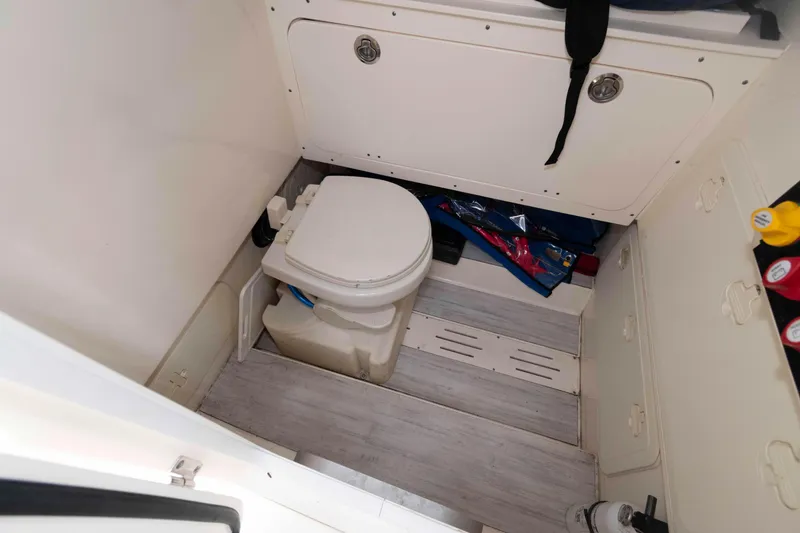 Slide: The Image of 2023 Scout 277 LXF boat interior with compact marine toilet and storage. - 21