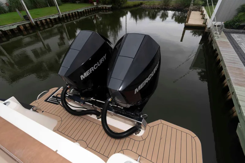 Slide: The Image of 2023 Scout 277 LXF boat with dual Mercury outboard engines on a wooden dock. - 23