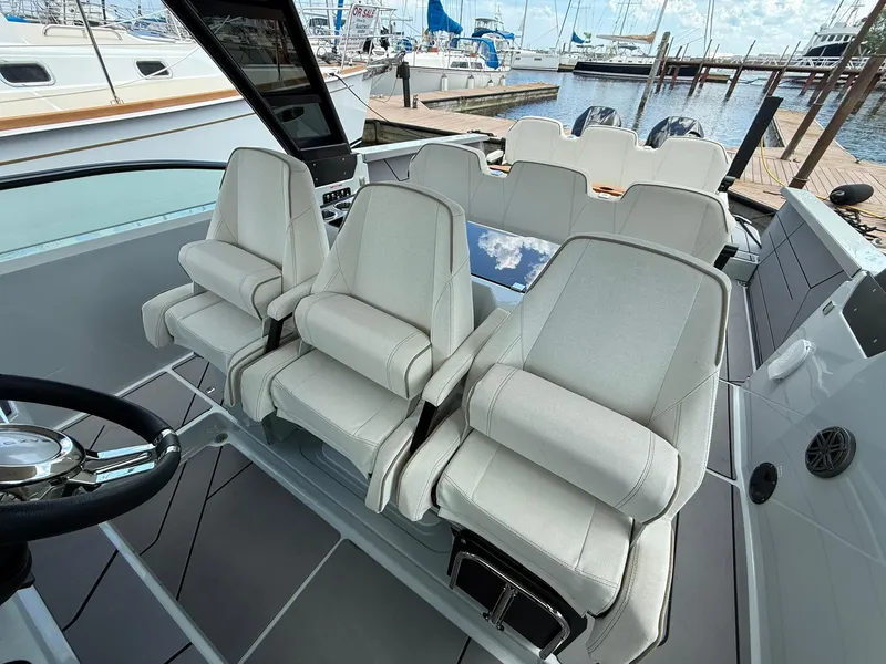 Slide: The Image of 2024 Saxdor 320 GTO boat interior with luxurious seating at a marina. - 15