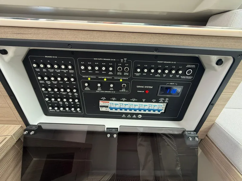 Slide: The Image of Control panel of 2024 Saxdor 320 GTO boat, featuring various switches and a digital display. - 27