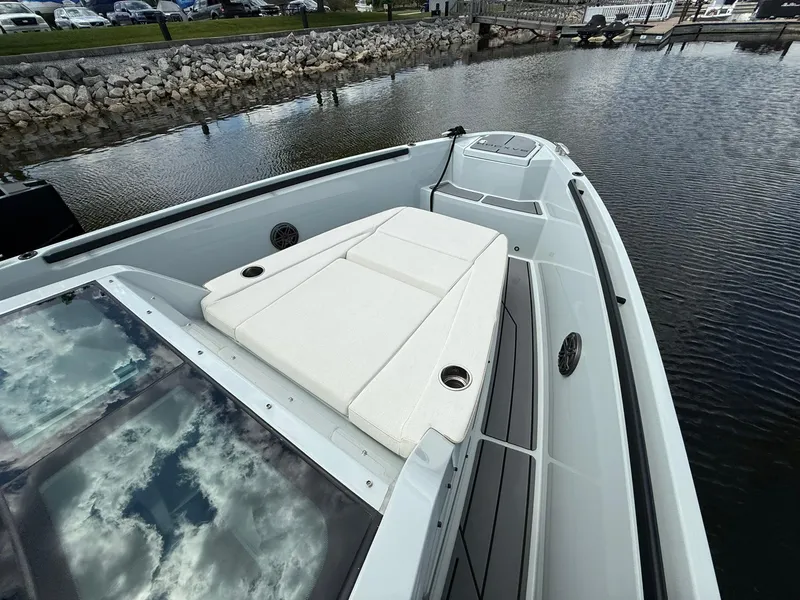 Slide: The Image of 2024 Saxdor 320 GTO boat with sleek deck design, docked by a rocky shoreline. - 5
