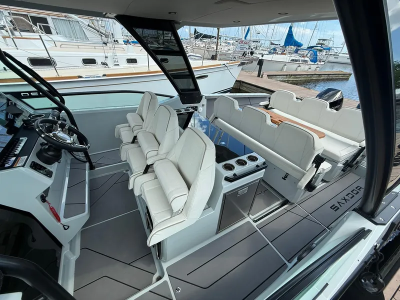 Slide: The Image of 2024 Saxdor 320 GTO interior with modern seating and sleek design at a marina. - 6