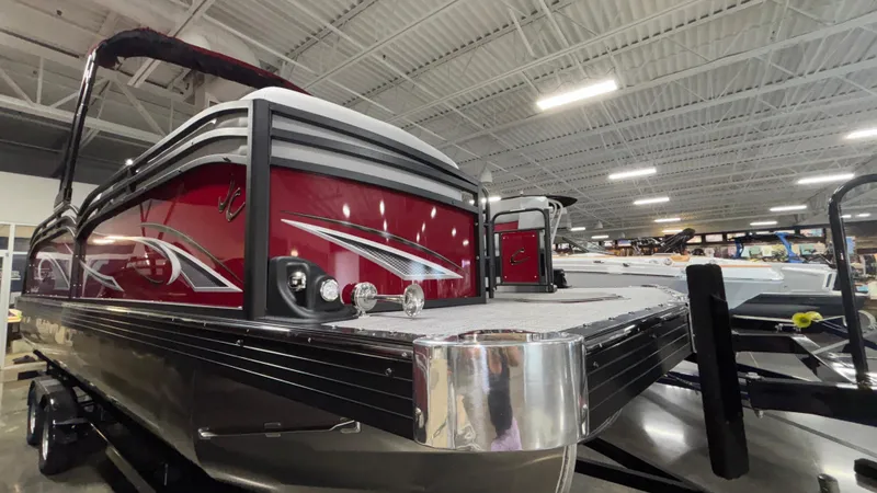 Slide: The Image of 2025 JC Neptoon 25TT Sport pontoon boat displayed indoors, featuring sleek red and silver design. - 31