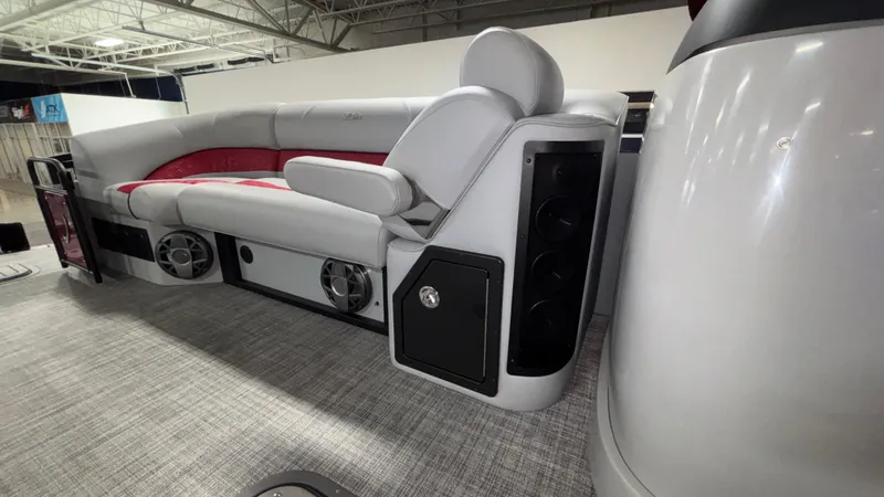 Slide: The Image of 2025 JC Neptoon 25TT Sport boat interior with gray and red seating, speakers, and modern design. - 19
