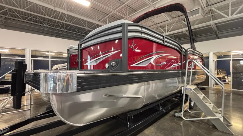The Image of 2025 JC Neptoon 25TT Sport pontoon boat in showroom, red and silver design. - 2