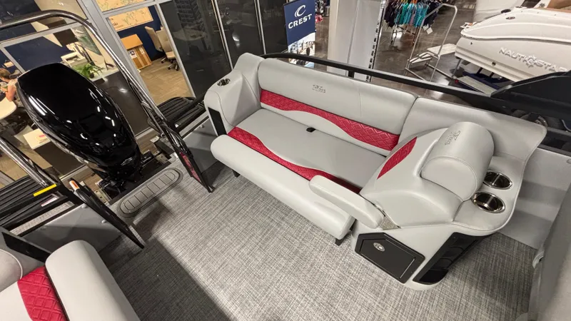 Slide: The Image of 2025 JC Neptoon 25TT Sport boat interior with gray and red seating, cup holders, and motor. - 7