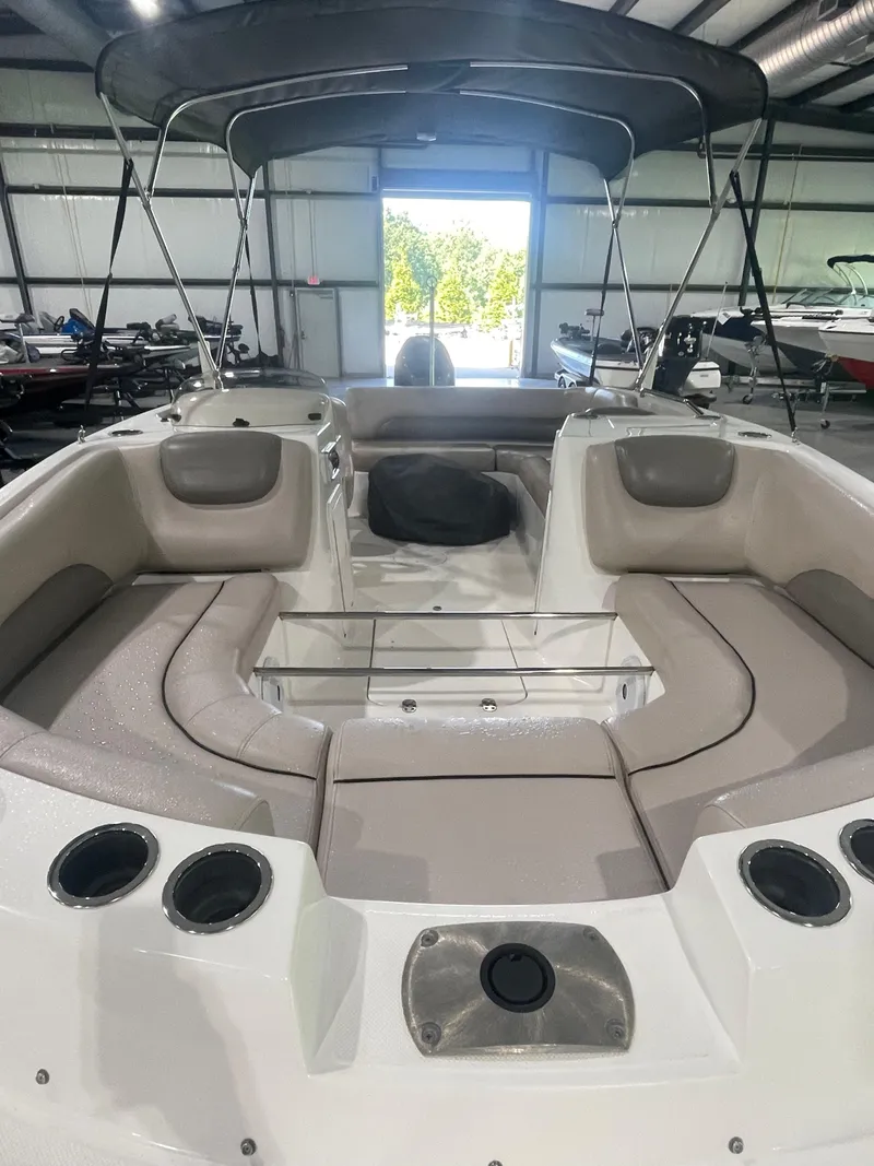 Slide: The Image of 2014 Hurricane SunDeck Sport 188 OB boat interior with seating and canopy in a showroom. - 10