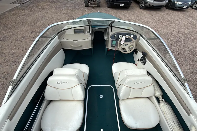 Slide: The Image of 1999 Bayliner 1800 Capri boat interior with white seats and steering wheel. - 1