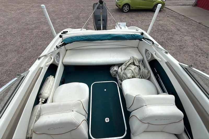 Slide: The Image of 1999 Bayliner 1800 Capri boat interior with white seating and green carpet. - 3