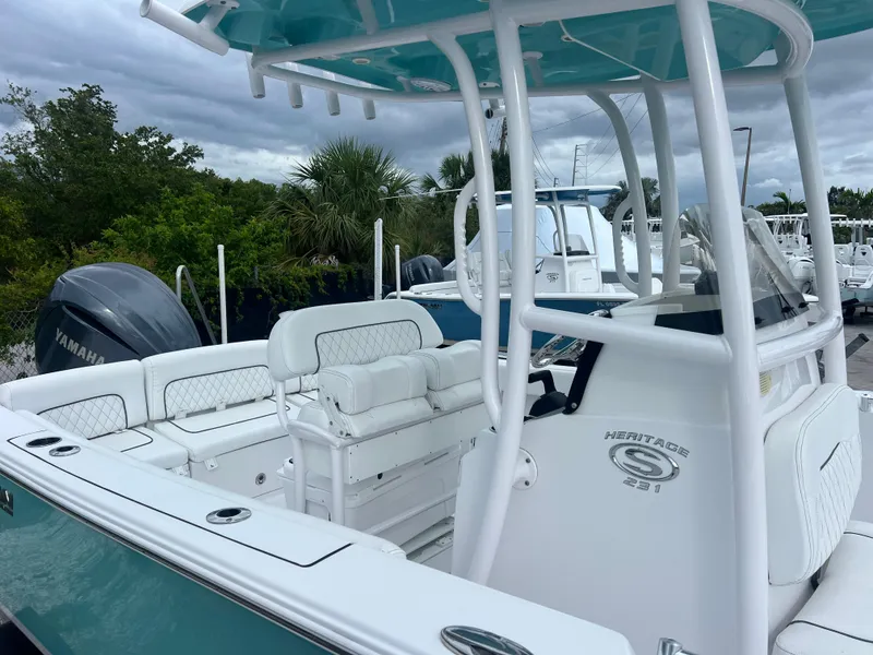 Slide: The Image of 2023 Sportsman Heritage 231 Center Console boat with white seating and teal accents. - 12