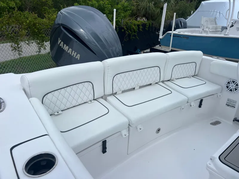Slide: The Image of 2023 Sportsman Heritage 231 Center Console boat with white cushioned seating and Yamaha engine. - 14
