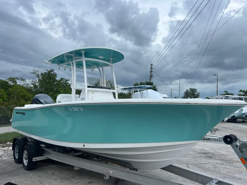 Slide: The Image of 2023 Sportsman Heritage 231 Center Console boat on trailer, under cloudy sky. - 2
