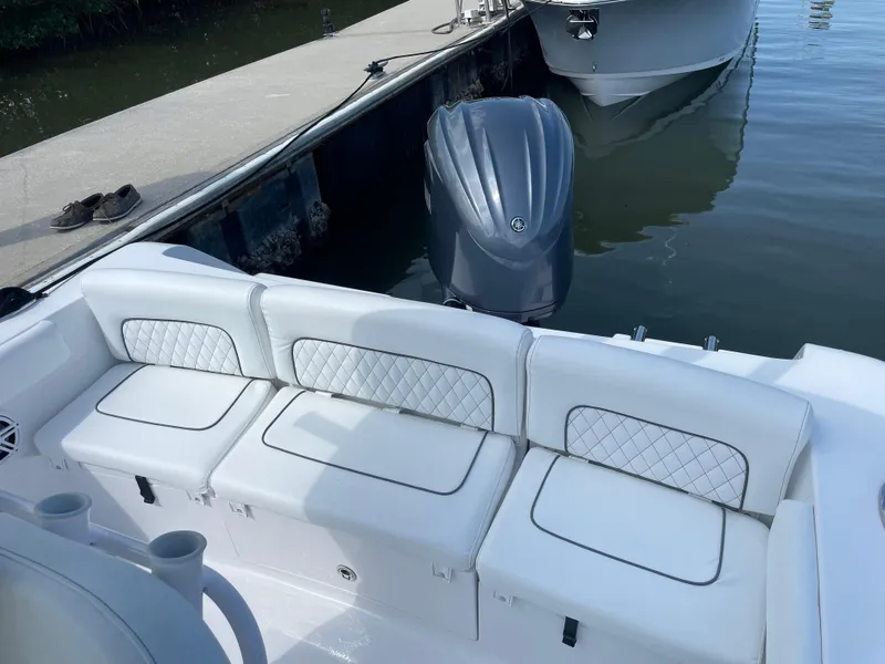 Slide: The Image of 2023 Sportsman Heritage 231 Center Console boat with white cushioned seating at dock. - 6