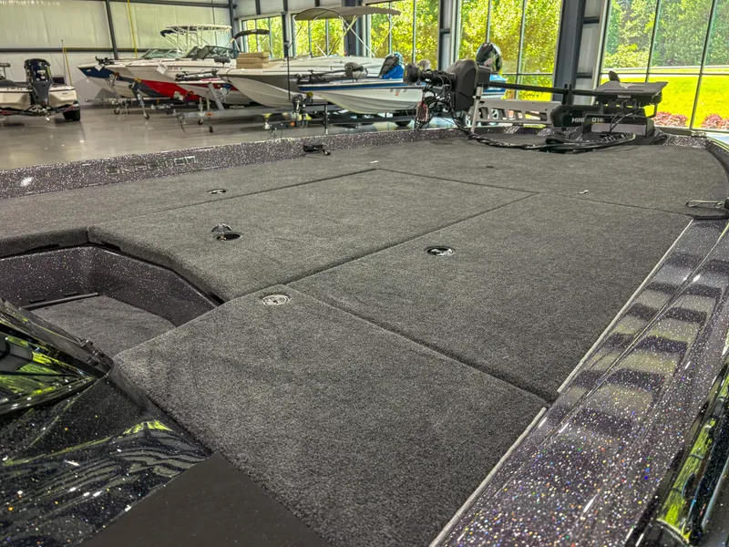 Slide: The Image of 2025 Skeeter ZXR 21 SE boat interior with spacious carpeted deck in showroom. - 11