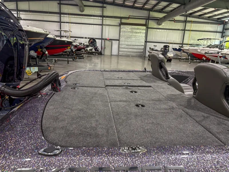 Slide: The Image of 2025 Skeeter ZXR 21 SE boat interior in showroom, featuring spacious deck and seating. - 5