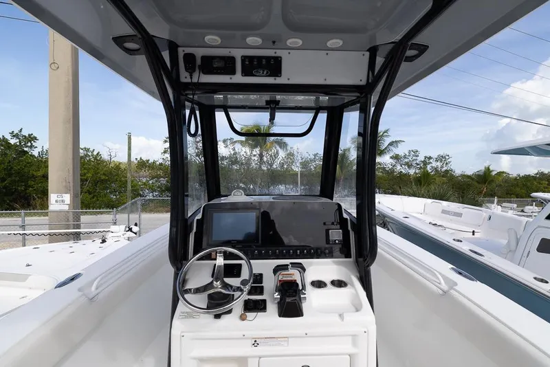 Slide: The Image of 2019 Sea Hunt Ultra 275 SE boat console with steering wheel and navigation equipment. - 13