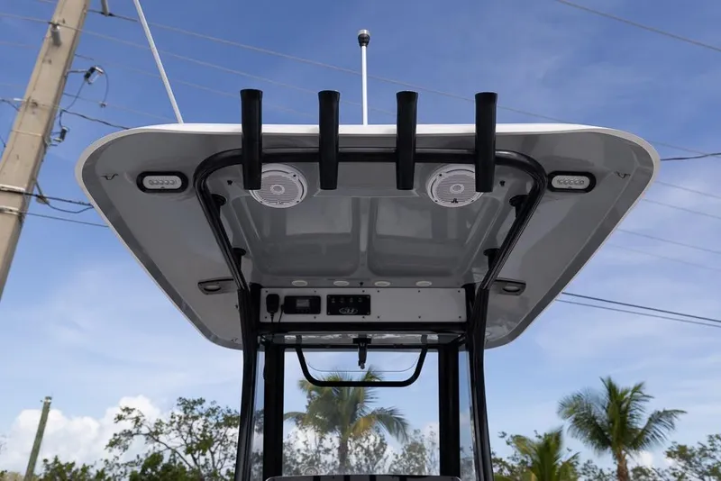 Slide: The Image of 2019 Sea Hunt Ultra 275 SE T-top with rod holders and speakers under blue sky. - 14