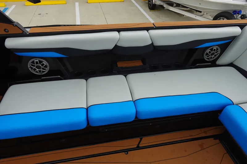 Slide: The Image of 2023 Axis T250 boat interior with blue and gray seating, featuring built-in speakers. - 16