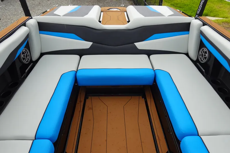 Slide: The Image of 2023 Axis T250 boat interior with blue and gray seating, featuring modern design and speakers. - 20