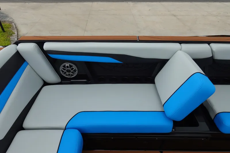 Slide: The Image of 2023 Axis T250 boat interior with blue and gray seating, featuring a built-in speaker. - 22
