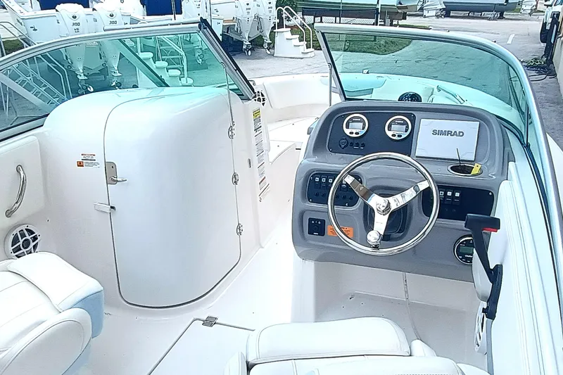 Slide: The Image of 2024 Robalo R207 Dual Console boat interior with steering wheel and dashboard controls. - 11