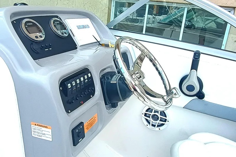 Slide: The Image of 2024 Robalo R207 Dual Console boat dashboard with steering wheel and control panel. - 13