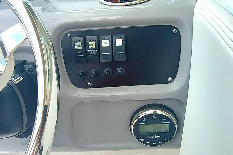 Slide: The Image of Control panel of 2024 Robalo R207 Dual Console boat with switches and Clarion audio system. - 16