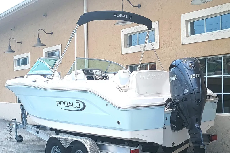 Slide: The Image of 2024 Robalo R207 Dual Console boat with Yamaha 150 engine on trailer. - 2