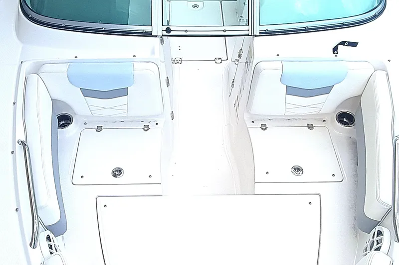 Slide: The Image of 2024 Robalo R207 Dual Console boat interior with white seating and storage compartments. - 23