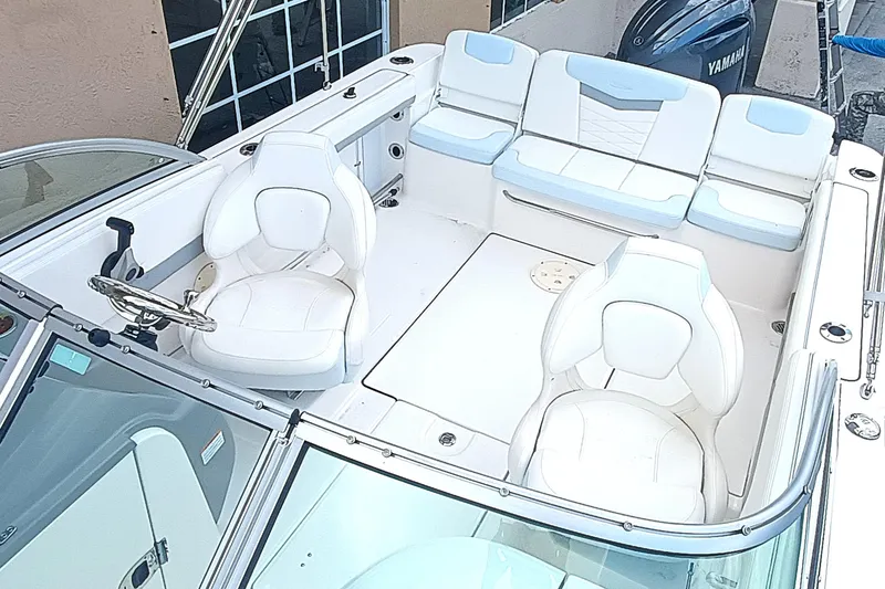 Slide: The Image of 2024 Robalo R207 Dual Console boat interior with white seating and steering wheel. - 25