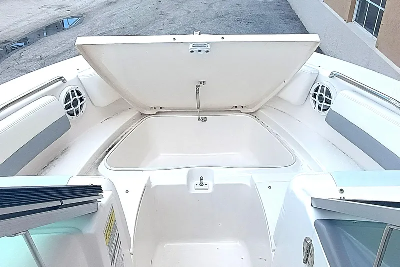 Slide: The Image of 2024 Robalo R207 Dual Console boat interior with open storage compartment and speakers. - 26