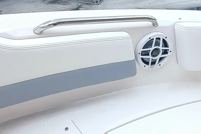 Slide: The Image of 2024 Robalo R207 Dual Console interior with speaker and stainless steel handrail. - 28