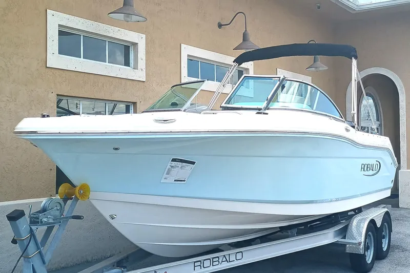 Slide: The Image of 2024 Robalo R207 Dual Console boat on trailer, parked outside a building. - 3