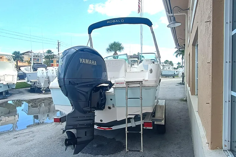 Slide: The Image of 2024 Robalo R207 Dual Console boat with Yamaha outboard motor, parked on a trailer. - 4