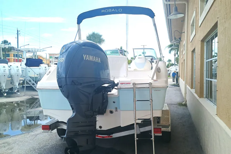 Slide: The Image of 2024 Robalo R207 Dual Console boat with Yamaha engine, parked near a building. - 6