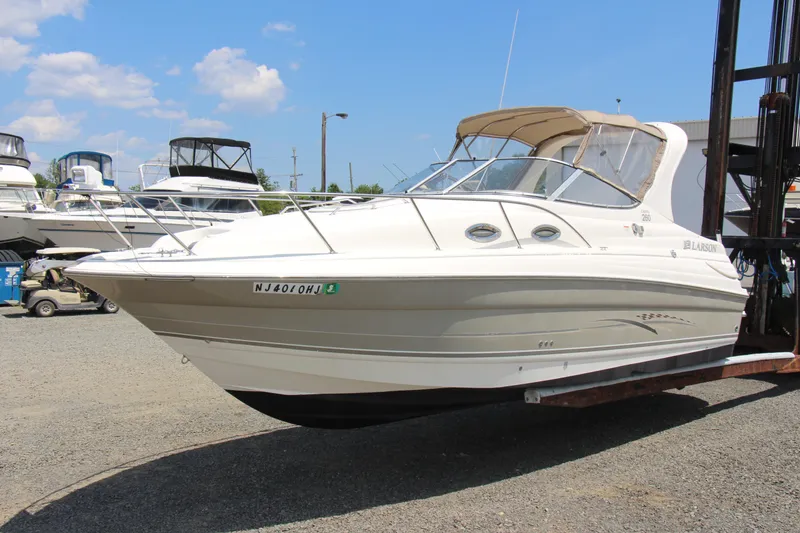 The Image of 2008 Larson Cabrio 260 boat on a trailer in a marina setting. - 0