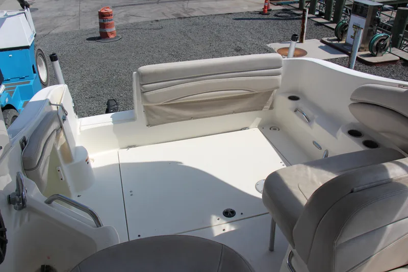 Slide: The Image of 2008 Larson Cabrio 260 boat interior with beige seating and cup holders. - 11