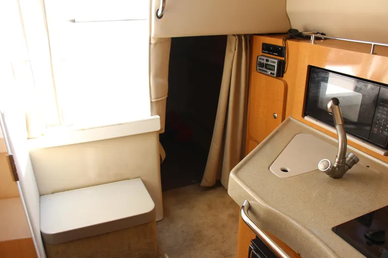 Slide: The Image of Interior of 2008 Larson Cabrio 260 boat with kitchenette and seating area. - 12