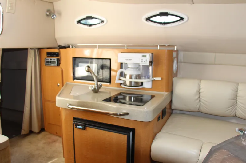 Slide: The Image of Interior of 2008 Larson Cabrio 260 boat with kitchenette and seating area. - 13