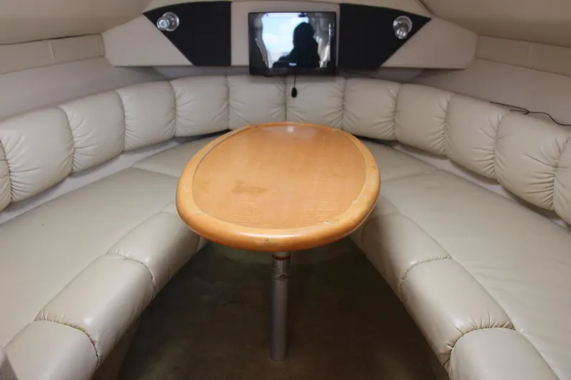 Slide: The Image of 2008 Larson Cabrio 260 interior with beige seating and wooden table. - 14