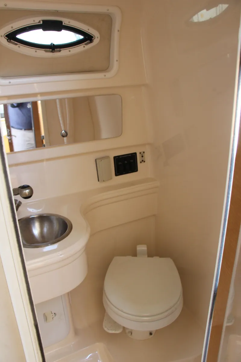 Slide: The Image of 2008 Larson Cabrio 260 boat bathroom with sink, toilet, and mirror. - 16