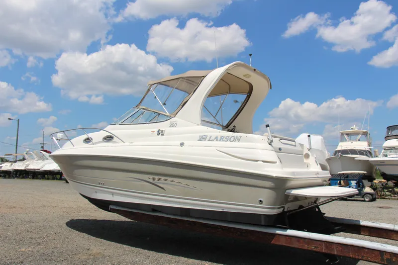 Slide: The Image of 2008 Larson Cabrio 260 boat on trailer under a blue sky with clouds. - 3