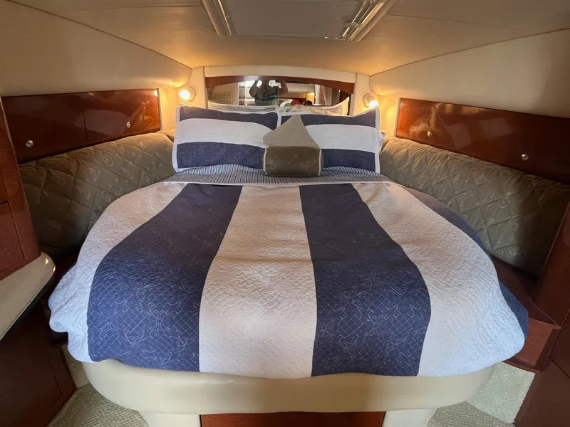 Slide: The Image of Cozy cabin interior of 2002 Sea Ray 320 Sundancer with striped bedding. - 22